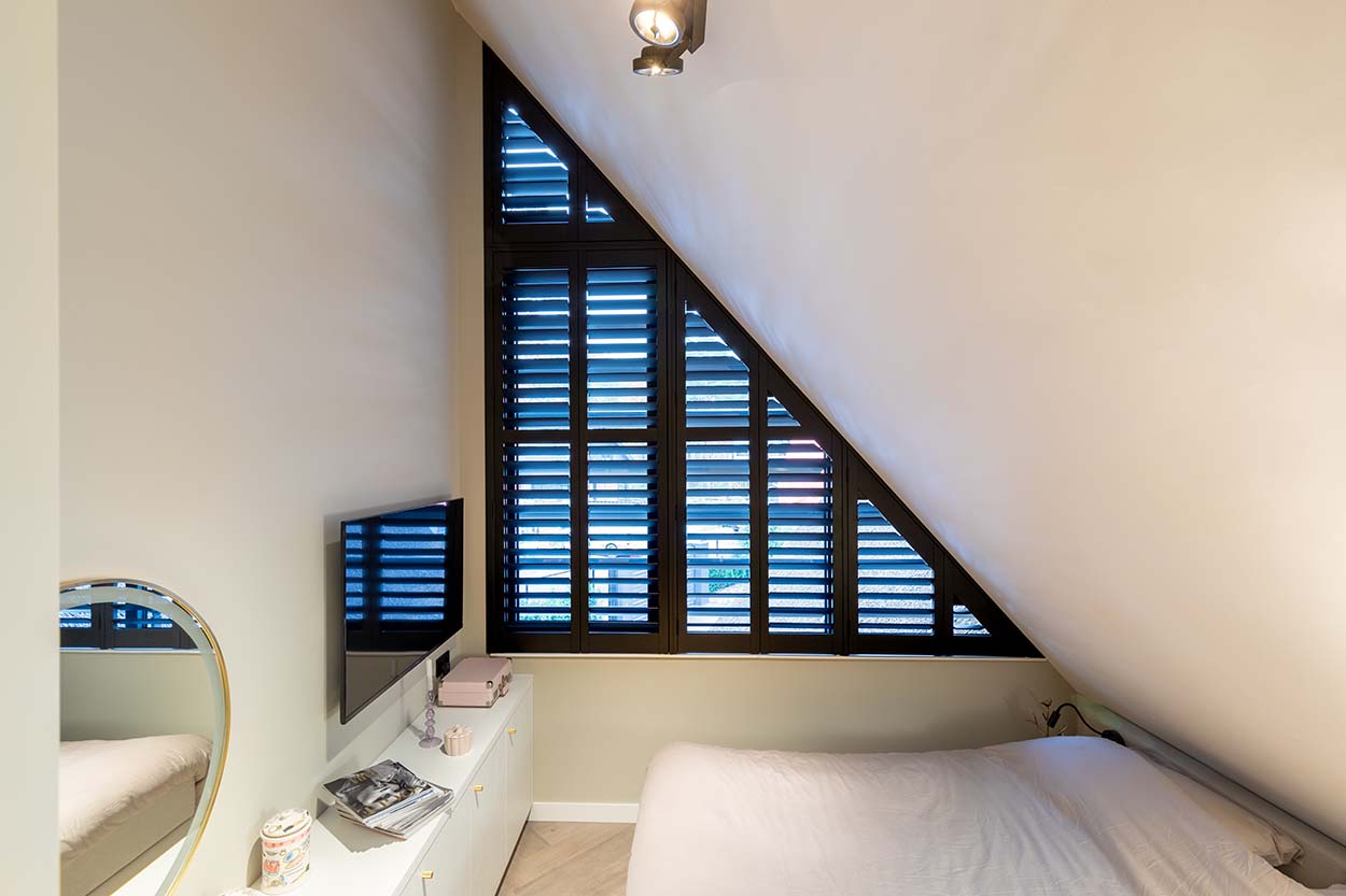 Shutters noirs dans une fenêtre triangulaire