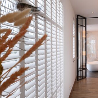 Grote witte shutters voor raam