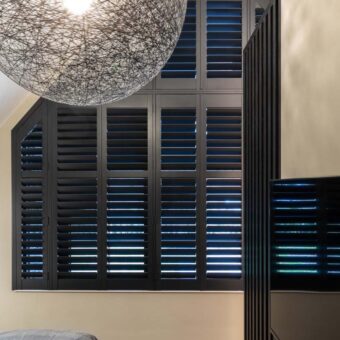 Slaapkamer met zwarte shutters in puntraam