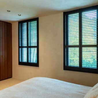 Zwarte shutters in stijlvolle slaapkamer