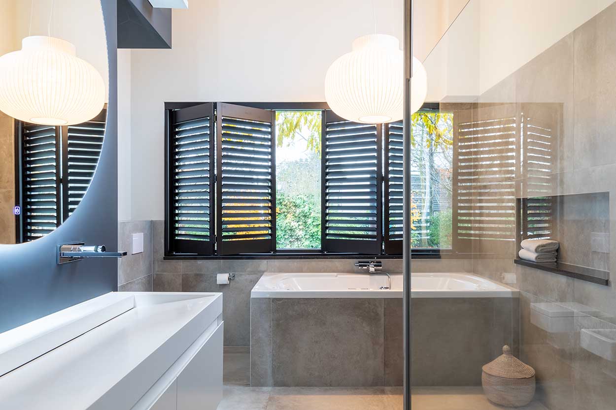 Shutters en plastique noir dans la salle de bains avec volets ouverts