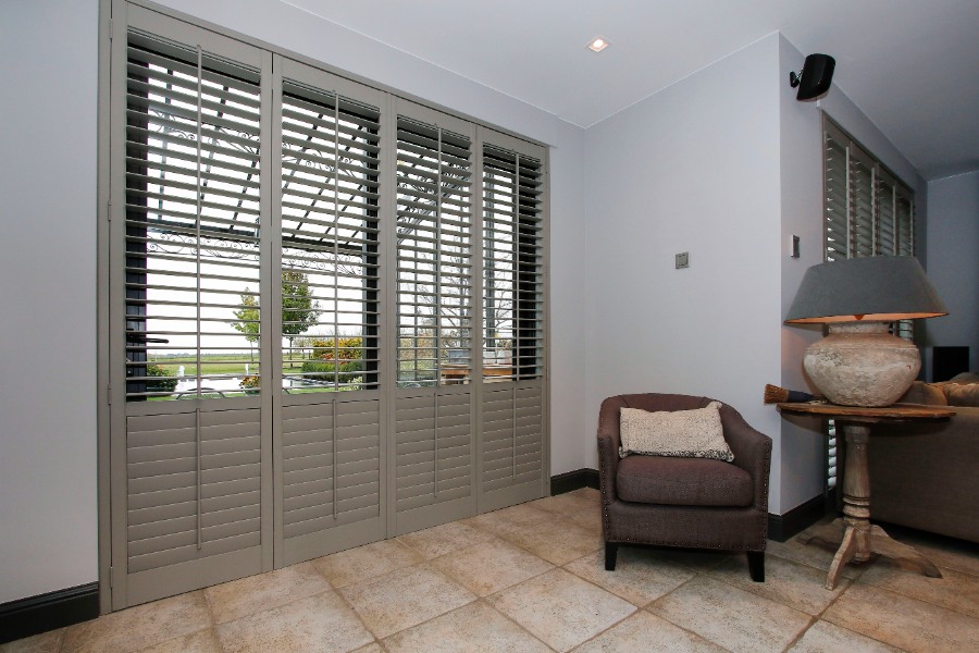 Grande fenêtre avec des shutters taupe entrouverts