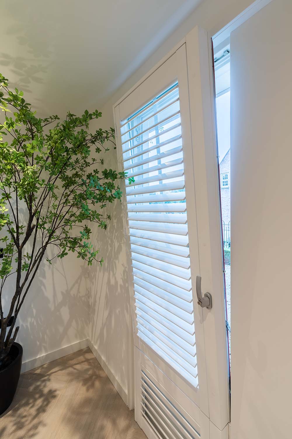 Shutters blancs sur fenetre oscillo battante