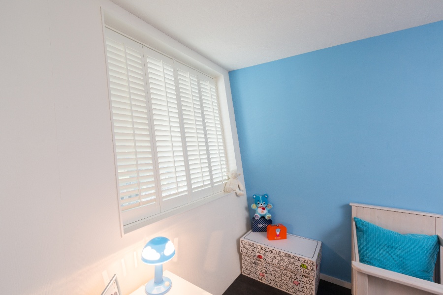 Mur bleu avec shutters blancs comme revetement de fenetre