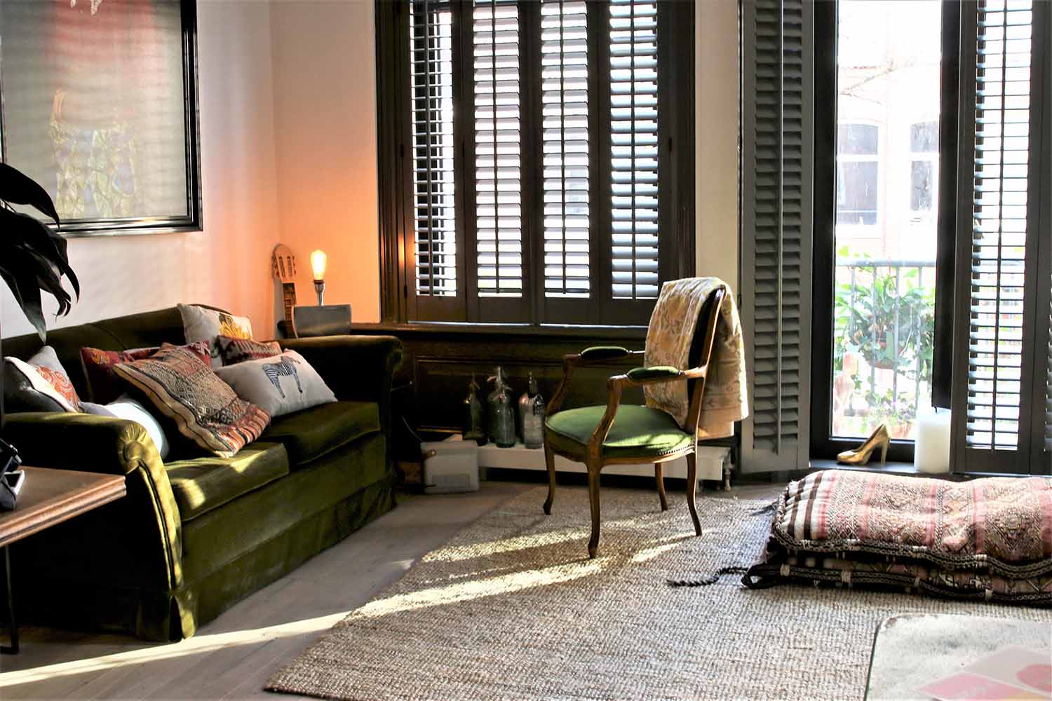 Zwarte shutters als raamdecoratie in woning in Afrikaanse sferen