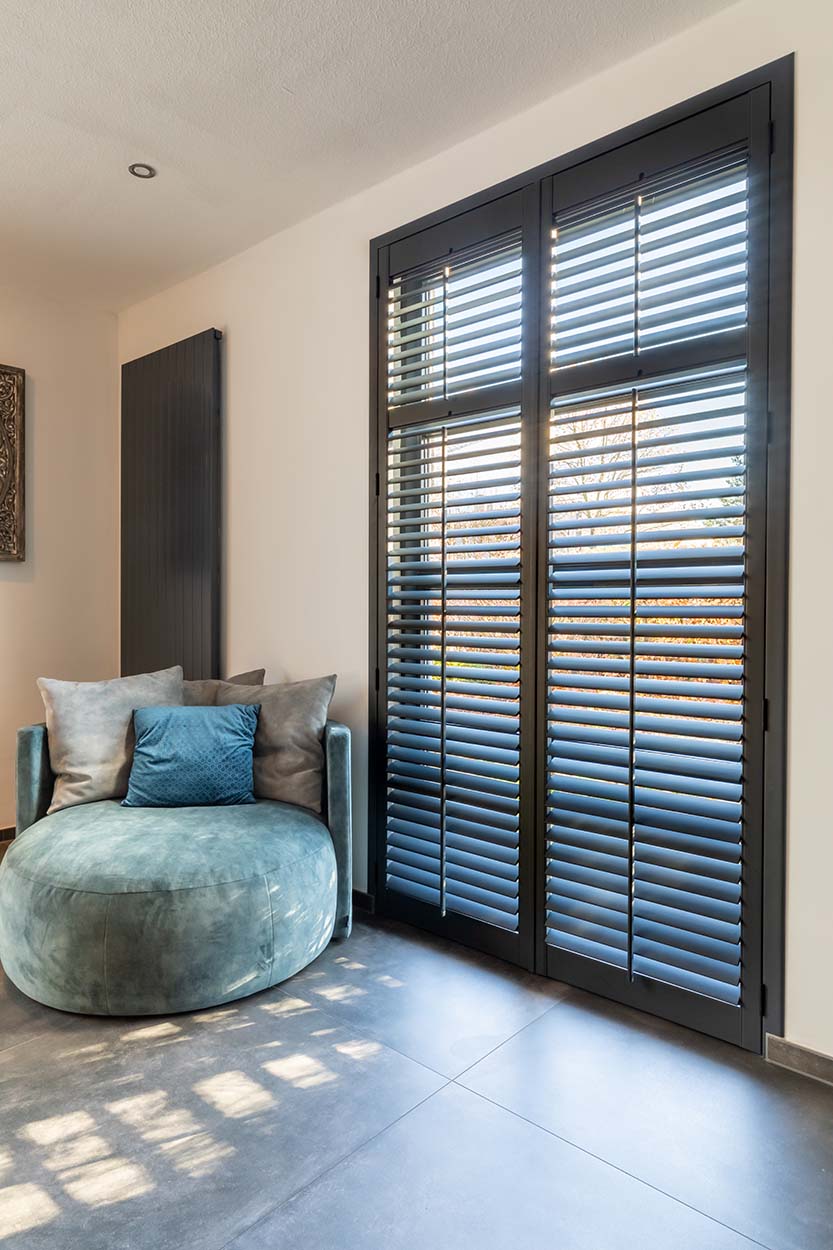 Donkere shutters met tilt rod in de woonkamer in Hotel Chic woonstijl