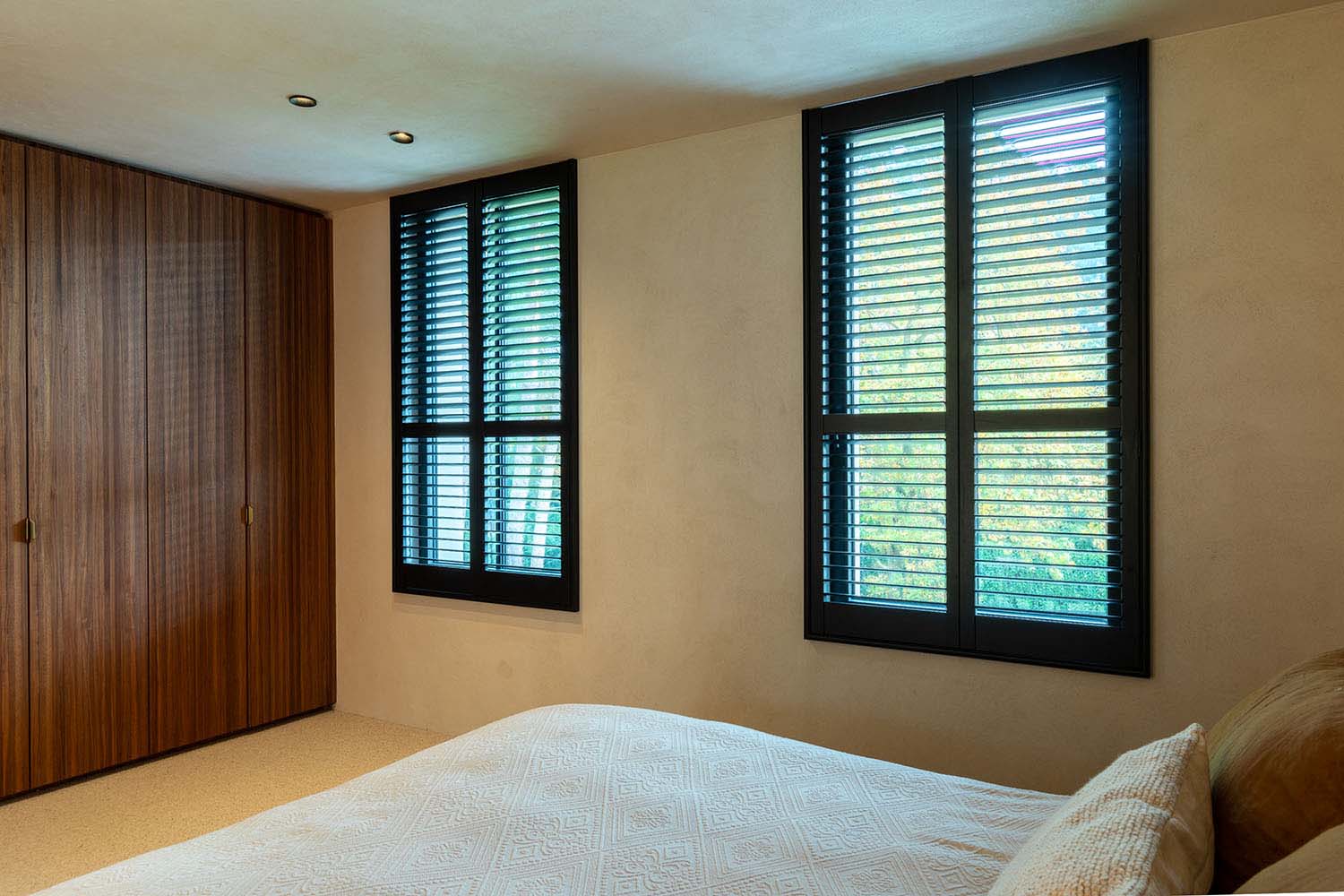 Hotel Chic slaapkamer met zwarte shutters als raamdecoratie