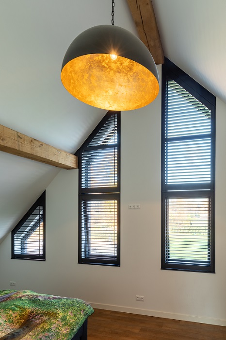 Schuin raam op de slaapkamer bekleedt met shutters als raamdecoratie