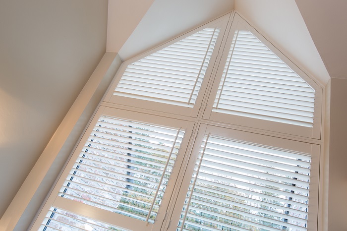 Witte shutters als raamdecoratie voor puntraam