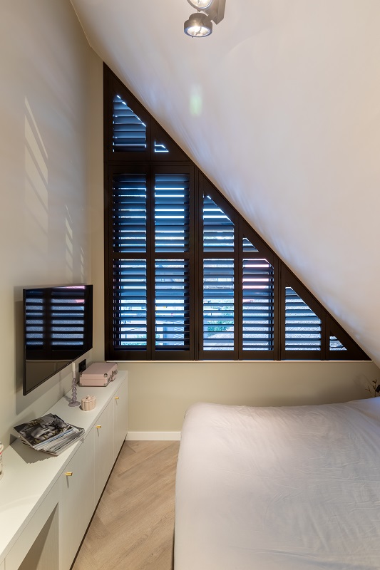 Driehoekig raam bekleedt met shutters als raamdecoratie