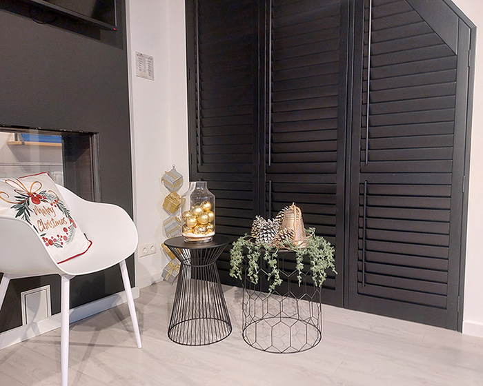 Zwarte raamdecoratie met interieur versierd met kerstdecoratie