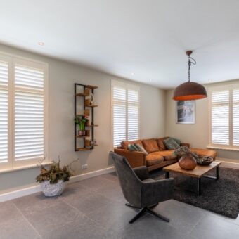 Woonkamer met offwhite shutters raambekleding