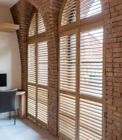 Mooie, houten shutters voor boogramen
