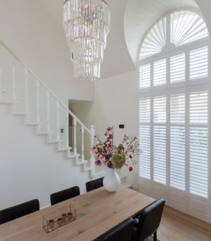 Witte shutters bij trap in hal