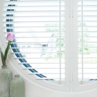 Klein rond raam met witte shutters