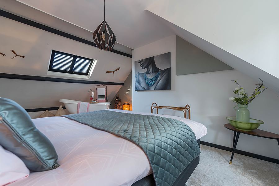 Slaapkamer met shutters in dakraam