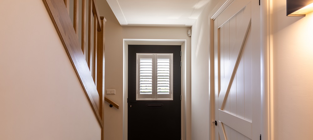Klein raam in voordeur met shutters