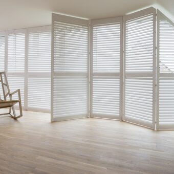 Grote ramen in serre met witte shutters