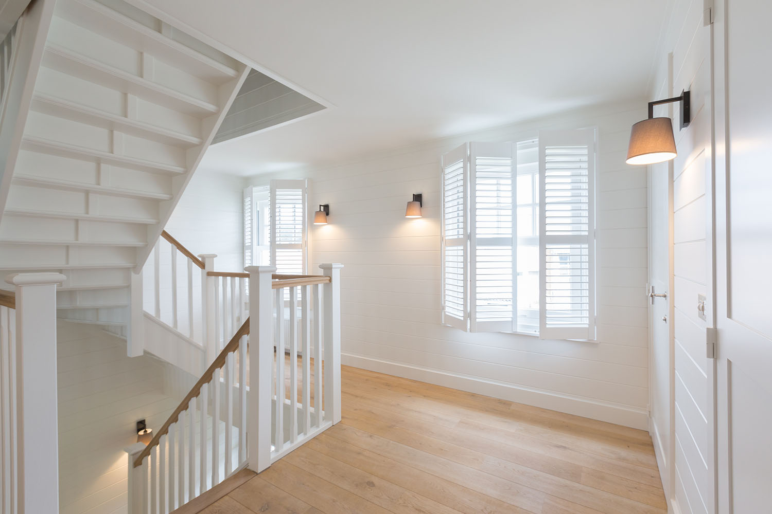 Overloop met witte shutters als raamdecoratie