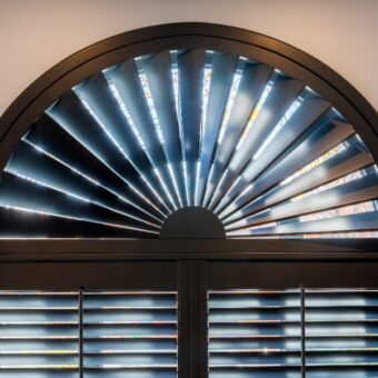 Zwarte shutters in halfrond raam