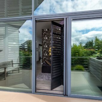 Buitenaanzicht van grote woning met shutters als raamdecoratie