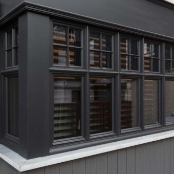 Buitenaanzicht van woning met erker en zwarte shutters