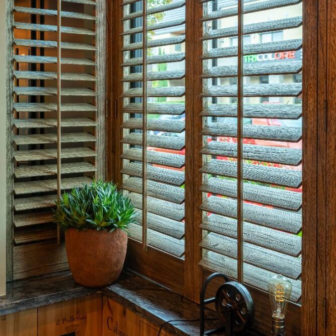 Bruinkleurige shutters met houtnerf en bedieningsstokje in herstinterieur