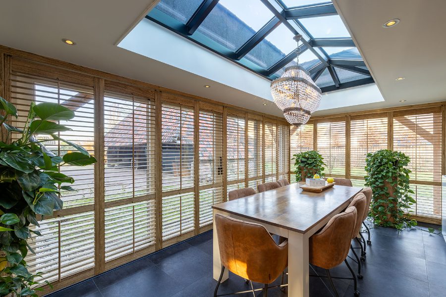 Shutters in beitskleur in moderne serre
