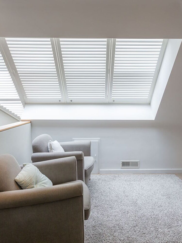 Witte shutters in dakraam op overloop