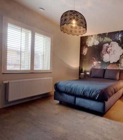 Donkerblauw bed met witte shutters