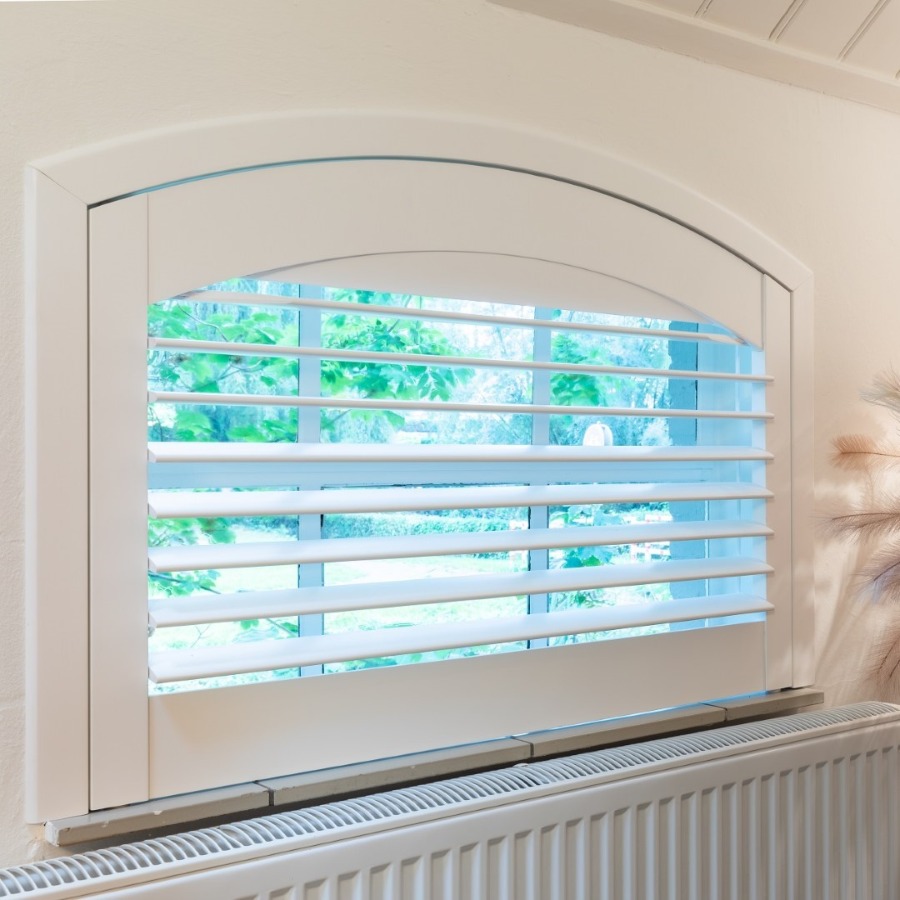 Klein halfrond raam met witte shutters