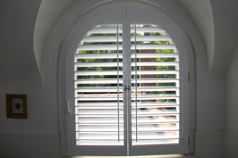 Witte shutters in boograam met tilt rod