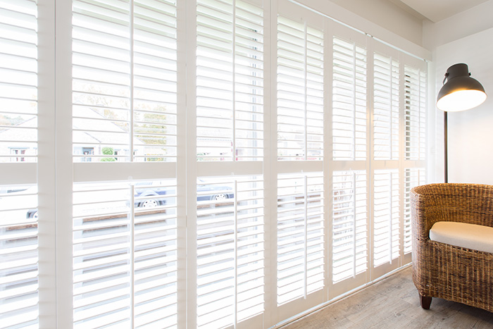 Witte shutters met tilt rod in lang raam