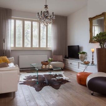 Woonkamer met offwhite shutters als raamdecoratie