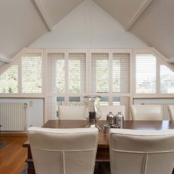 Woonkamer met offwhite shutters als raamdecoratie