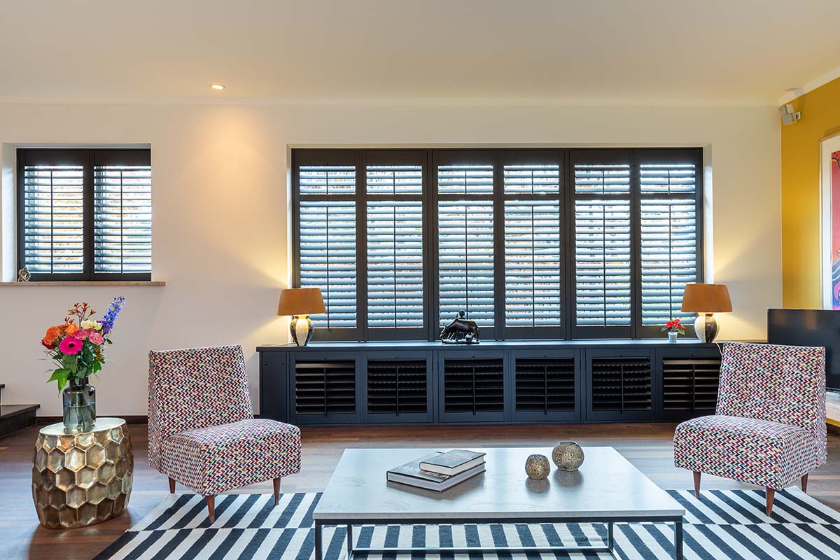 Zwarte shutters met lichte houtnerf radiator bekleedt