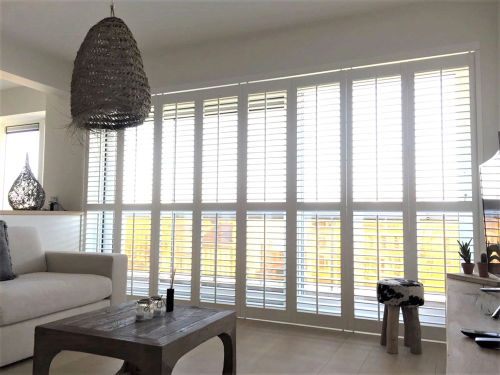 witte shutters voor een schuifpui