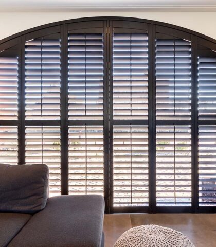 Zwarte shutters in gebogen raam