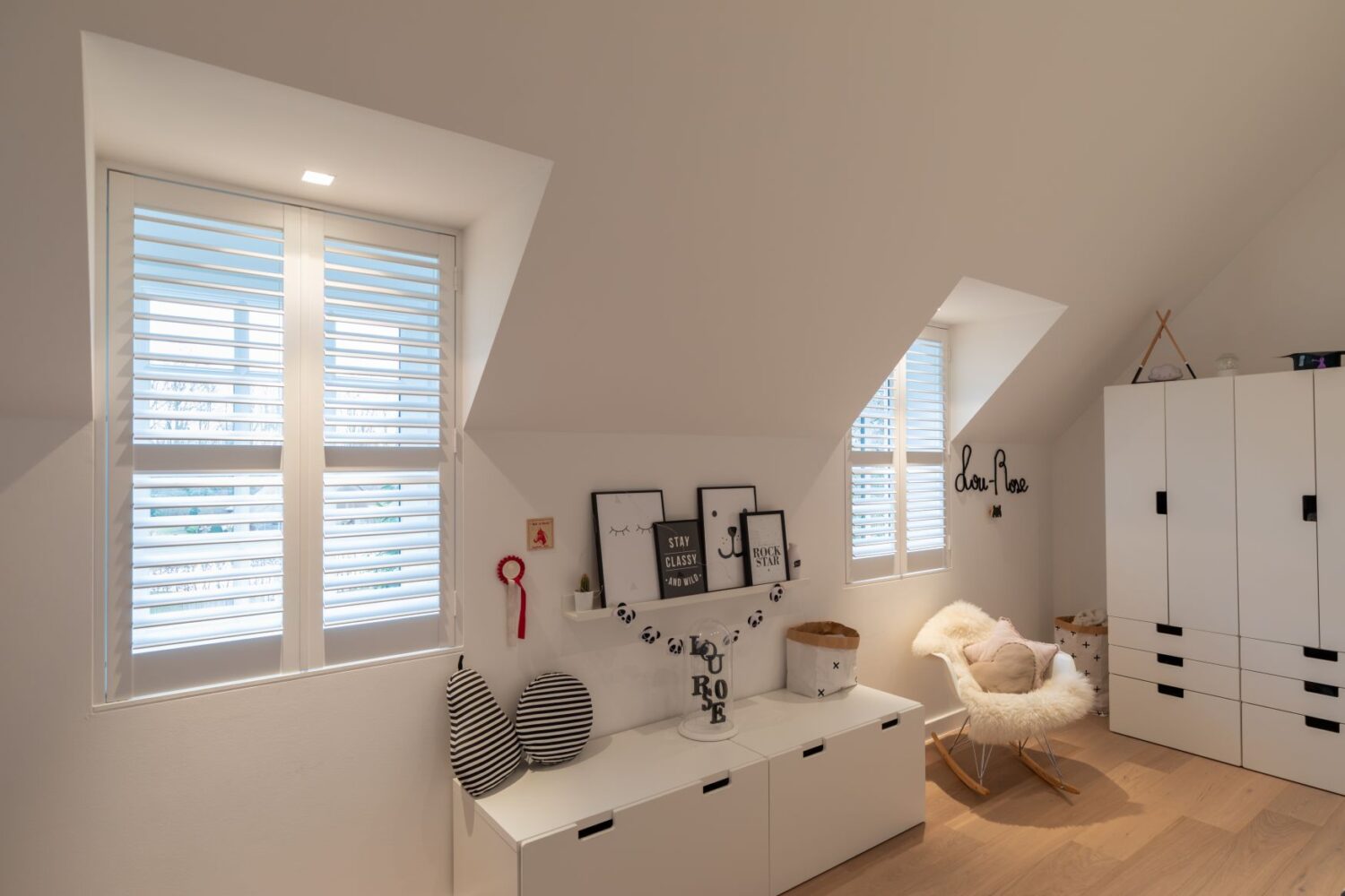 Witte shutters half open in dakkapel op babykamer
