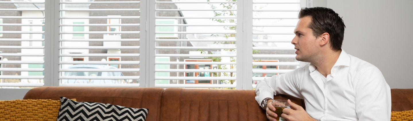 Witte shutters voor raam in woonkamer
