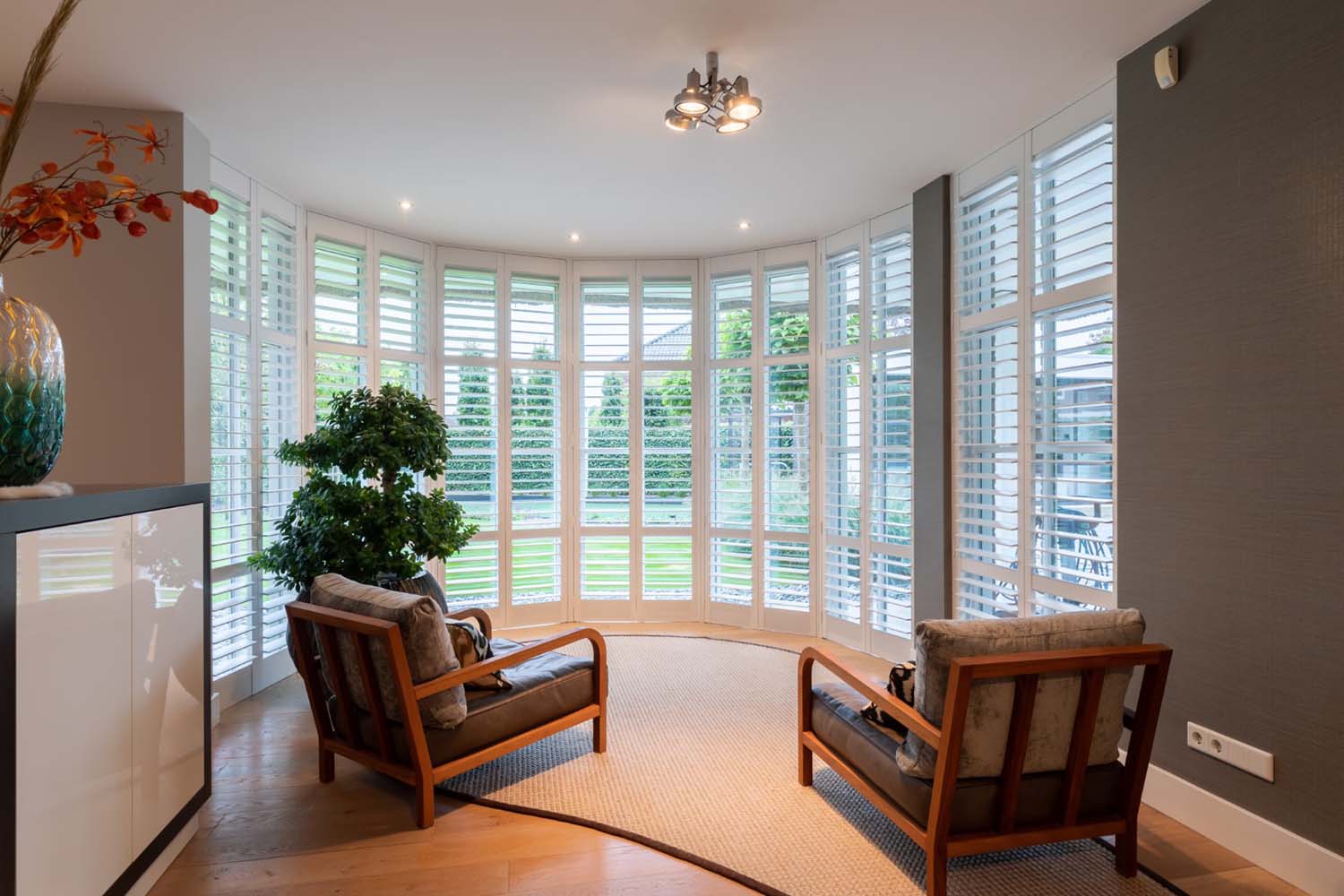 Witte houten shutters in woning met ronde erker