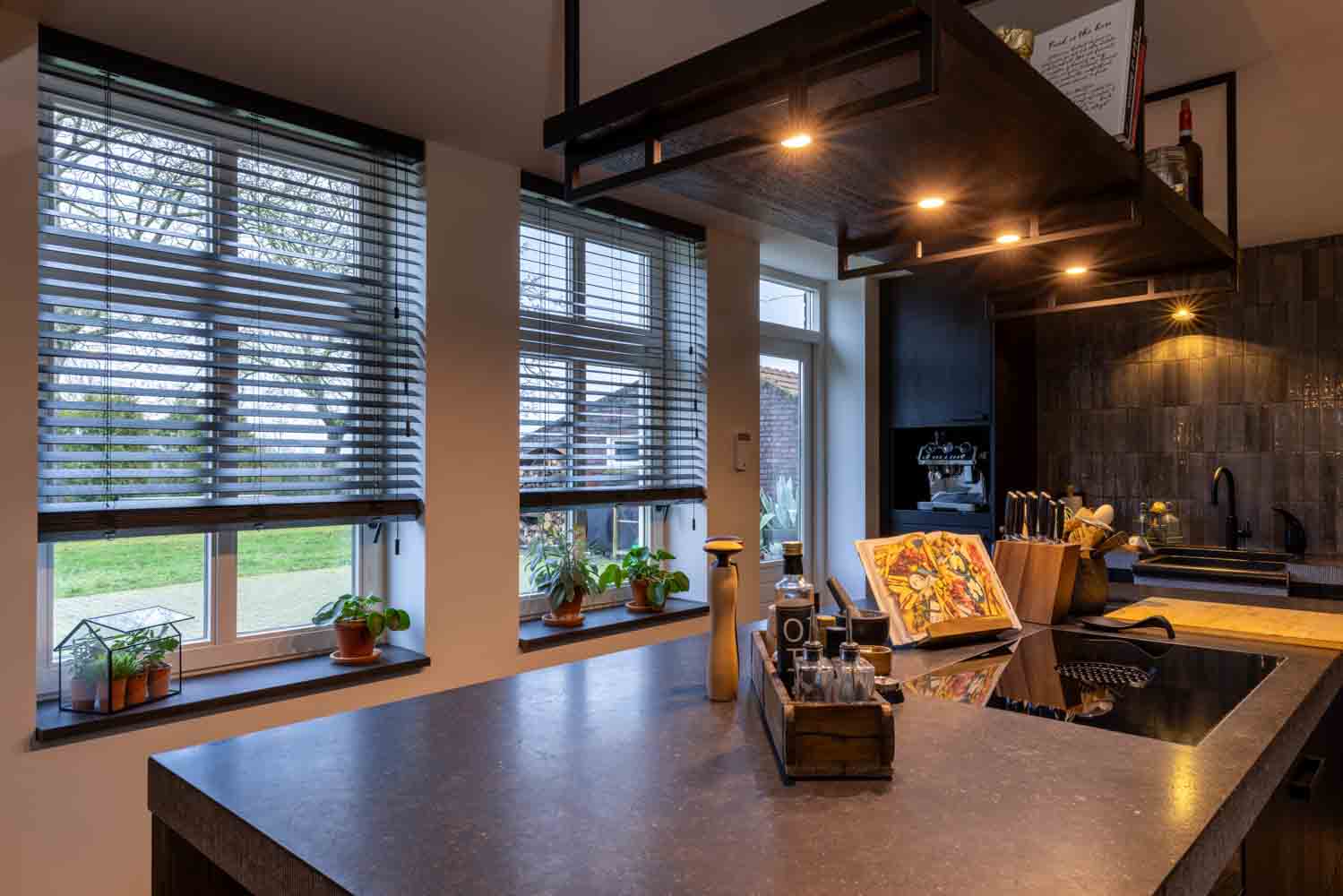Keuken in nieuwe woning met kookeiland en jaloezieën als raambekleding met elektrische bediening
