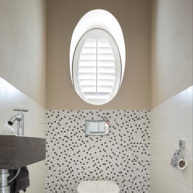 Wc met witte shutters in ovaal raampje